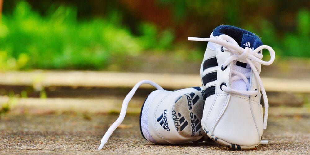 White Adidas Cushioned
baby shoes placed on the ground outdoors