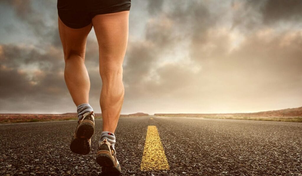 A person running on an open road, focusing on shoes and legs